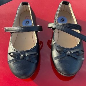 Toddler girls black dress goes with a bow on the top. Velcro strap